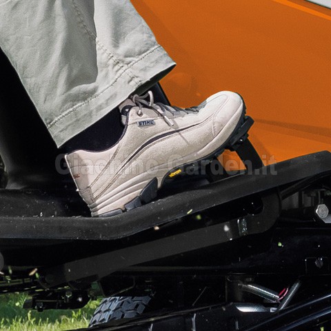 Primo piano di un piede su un pedale di un trattorino tagliaerba STIHL, evidenziando il sistema di trazione a pedale singolo