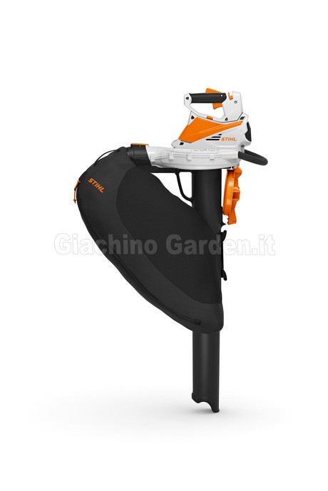 Vista laterale dello STIHL SHA 56 in modalità aspirafoglie, posizionato verticalmente. Mostra il corpo motore superiore bianco e arancione, l'ampio sacco di raccolta nero agganciato di lato e il lungo tubo di aspirazione rivolto verso il basso.