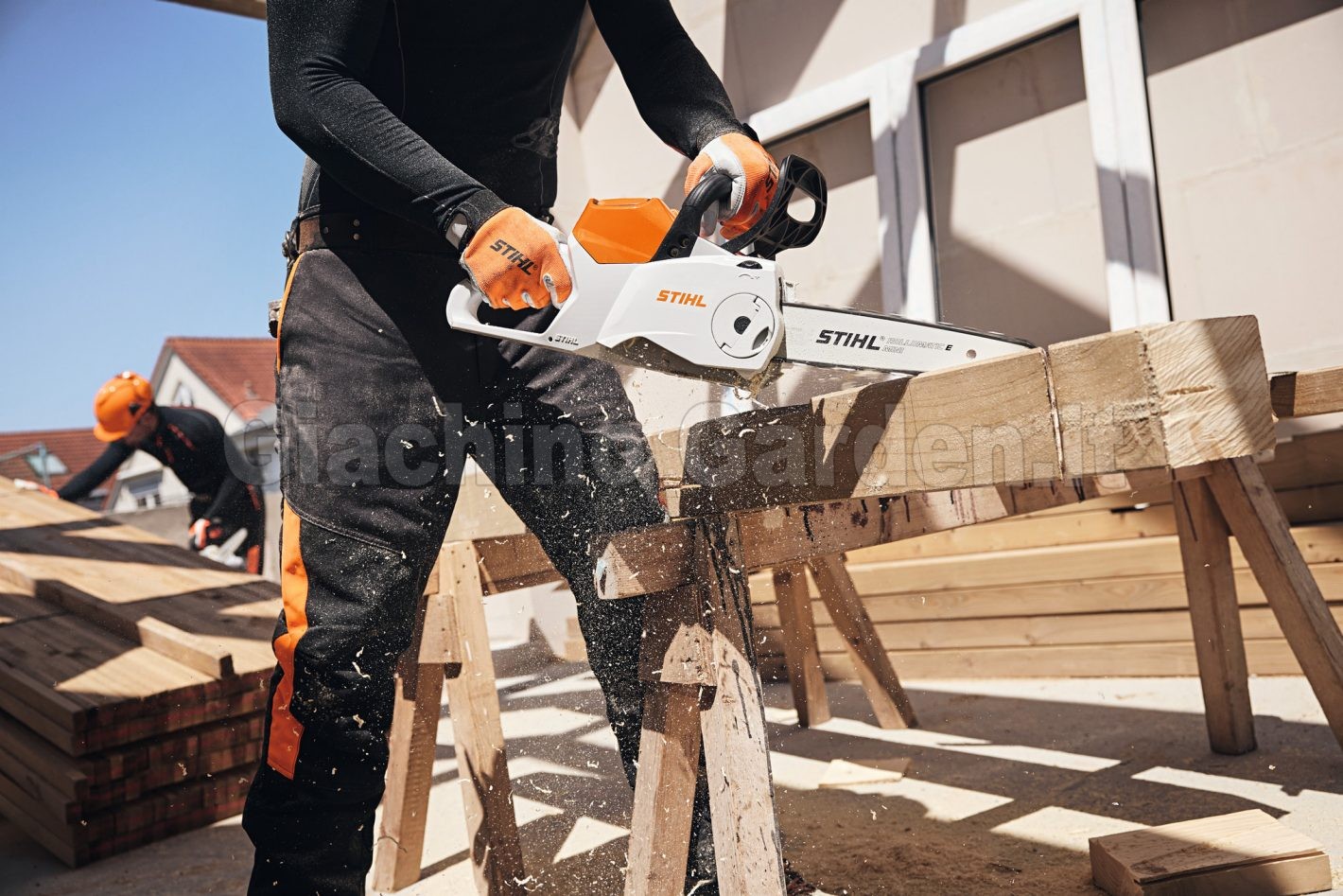 Operaio edile taglia travi in legno in un cantiere con la motosega a batteria Stihl MSA 160 C-B
