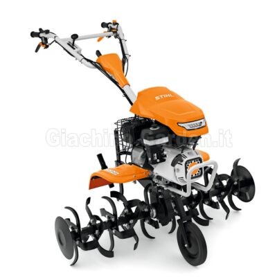 Motozappa STIHL MH 700 inquadrata di tre quarti con focus sulla ruota anteriore di trasporto, fari integrati e dischi proteggipiante laterali