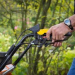 Impugnatura e leve di controllo della macchina rigeneratrice prato Eliet DZC 600 guidata da un operatore.